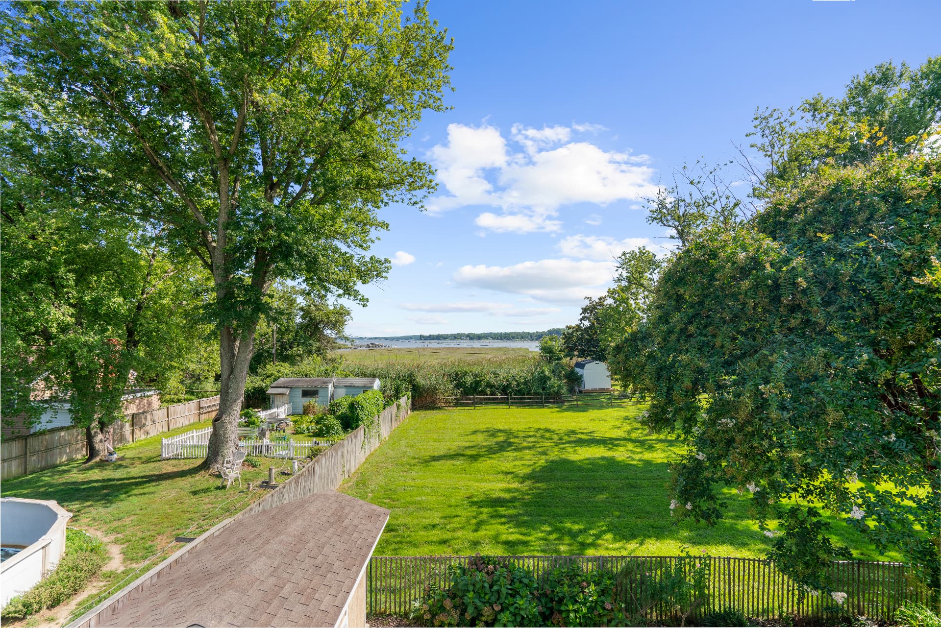 Spacious grassy backyard with marsh and water views